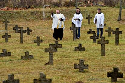 Un sacerdote católico de Bielorrusia bendice tumbas en el cementerio de Baruny, a unos 110 km al noroeste de Minsk.