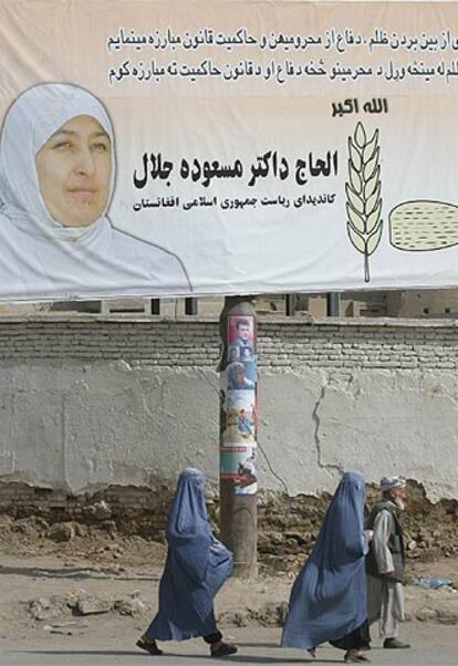 Mujeres afganas caminan bajo un cartel electoral de Masuda Jalai, ayer en Kabul.