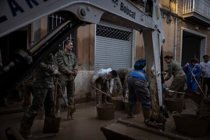 Tareas de limpieza con una miniexcavadora en un calle de Paiporta, el lunes.