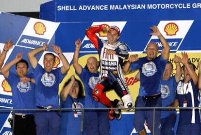 Jorge Lorenzo, en el centro, celebra junto a su equipo la victoria en el Mundial de motociclismo.
