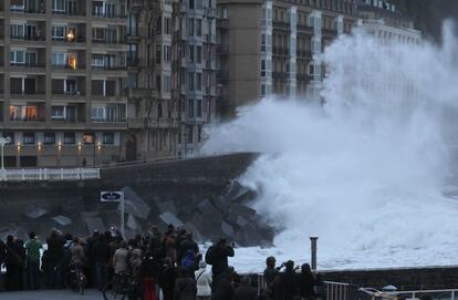 Un grupo de curiosos observa las olas desde el Kursal de San Sebastián.