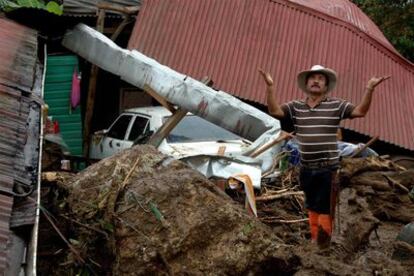 Un hombre reza frente a una casa destrozada en San Antonio de Escazu, a las afueras de San José (Costa Rica), donde el temporal ha dejado 20 muertos.