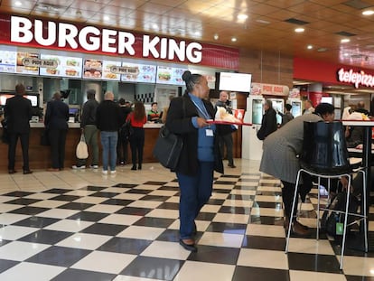 Varios asistentes a la cumbre del clima consumen comida rápida de Burger King en envases de plástico.