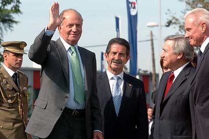 EL rey Juan Carlos saluda ayer al llegar a la fábrica de Nestlé, junto a Miguel Ángel Revilla y directivos de la empresa.