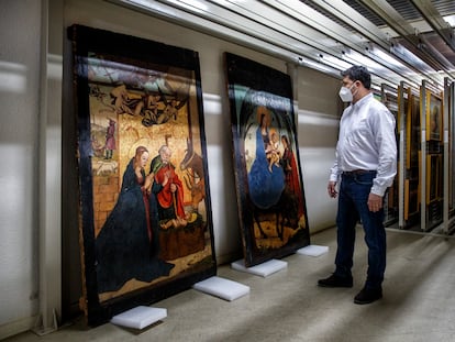 Pablo Nieto, restaurador de las ocho tablas de Juan de Borgoña halladas en Alcaraz, ante 'La Natividad' y ´La huida a Egipto' en los almacenes del Museo de Albacete.