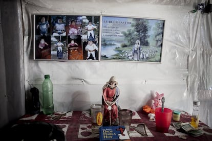 Imagen de la primera hija de Sulma y un pequeño altar religioso sobre una mesa en la esquina de la habitación de su casa. Esta niña falleció a los pocos meses.
