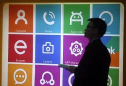 Un hombre pasea ante un panel luminoso en el Mobile World Congress de Barcelona.