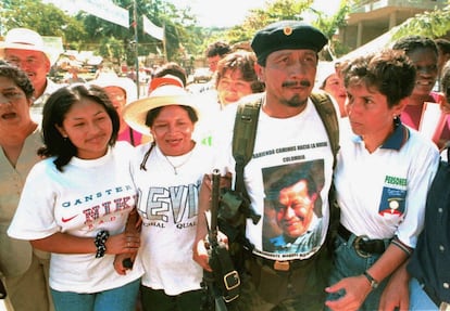 El comandante rebelde Jairo (FARC), camina junto a tres madres que preguntan por la liberación de sus hijos prisioneros del Ejército colombiano.

 SVC01:COLOMBIA-PEACE:SAN VICENTE DEL CAGUAN.COLOMBIA.8JAN99 - Leftist rebel commander "Jairo" walks accompanied by three mothers who have asked for the release of their sons, January 8. Their sons are among police and soldiers taken prisoners by guerrillas in different combats in the last year and rebels are now demanding to exchange them for jailed guerrillas. The civil conflict has claimed more than 35,000 lives and forced more than one million peasants to leave their homes in the last 10 years.     jmg/Photo by Henry Romero REUTERS