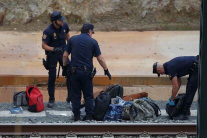 Agentes de la Polic&iacute;a Nacional retiran de la v&iacute;a algunas de las pertenencias de los viajeros que iban en el tren accidentado. 
