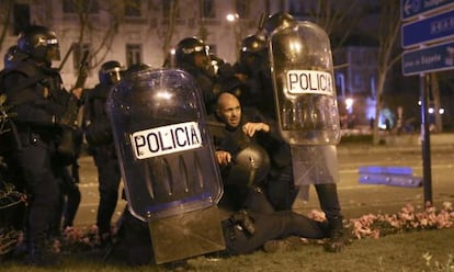 Antidisturbios el pasado s&aacute;bado en las marchas del 22-M se protegen del lanzamiento de botellas, piedras y petardos.