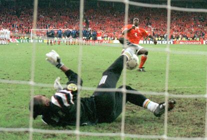 El guardameta ( portero) francés, Bernard Lama, detiene un penalti de Clarence Seedorf ( D) de la selección de Holanda, en el partido de cuartos de final de la Eurocopa. Francia ganó a Holanda, en la ronda de penaltis por 5 goles a 4. 22/06/1996.