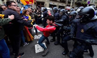 Protesters clash with riot police in the center of Barcelona after the arrest of Carles Puigdemont on March 25.