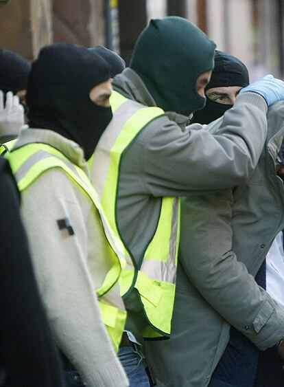 Tapado con su chaqueta, un arrestado ayer en Barcelona.