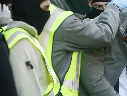 Tapado con su chaqueta, un arrestado ayer en Barcelona.