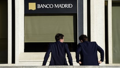 Dos personas conversan frente a una oficina del Banco Madrid, en 2015 en la capital.