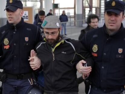 Dos agentes arrestan a un miembro de la plataforma.