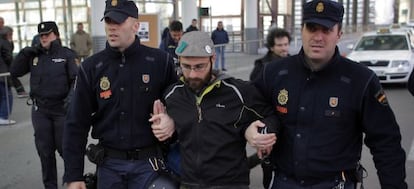 Dos agentes arrestan a un miembro de la plataforma.