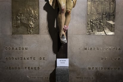 Detalle de un cartel donde se indica la prohibición de besar a una figura de un Cristo, en la capilla de San Fermín, el 7 de julio.