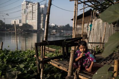 Una niña cepilla sus dientes junto a su hogar en Korail, el barrio de chabolas más grande de la ciudad. Se encuentra rodeado por los lagos de Gulshan y Banani, los dos barrios más ricos de Dacca.