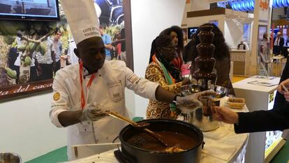 Un cocinero ofrece chocolate a los visitantes en el stand de Costa de Marfil