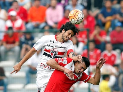 El mediocampista Hudson disputa el bal&oacute;n con Enrique Triverio.