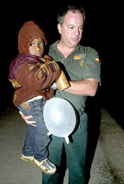 Un agente de la Guardia Civil sostiene en brazos al pequeño Thomas.