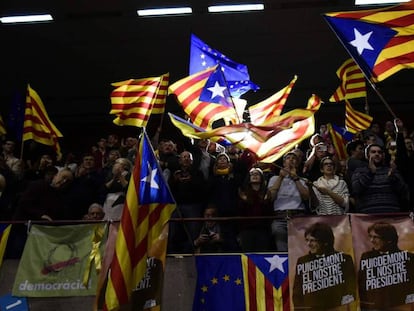 Un grupo de asistentes a un mitin de Junts per Catalunya agita esteladas, senyeras y banderas de la Uni&oacute;n Europea.