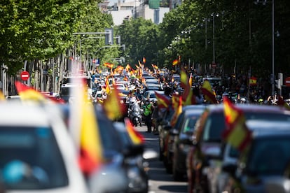 Coches y motos, con pancartas y banderas de España, circulan por las calles de Madrid en la manifestación de Vox para pedir la dimisión del Gobierno.