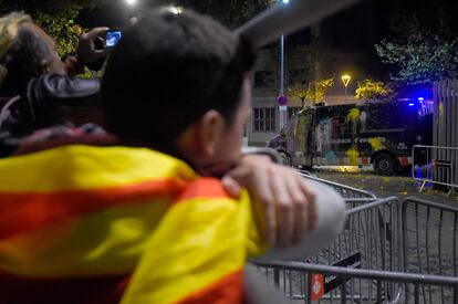Un manifestante observa una furgoneta antidisturbios llena de pintura, en Barcelona.