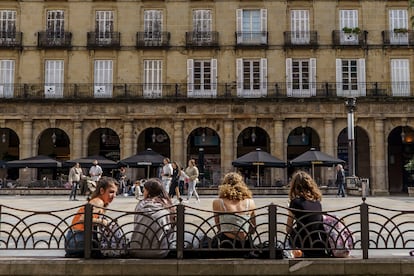 Varias jóvenes descansan en los bancos de la plaza Nueva de Bilbao.