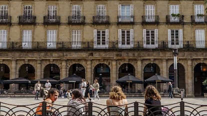 Varias jóvenes descansan en los bancos de la plaza Nueva de Bilbao.