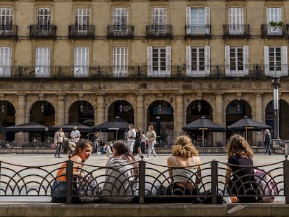 Varias jóvenes descansan en los bancos de la plaza Nueva de Bilbao.
