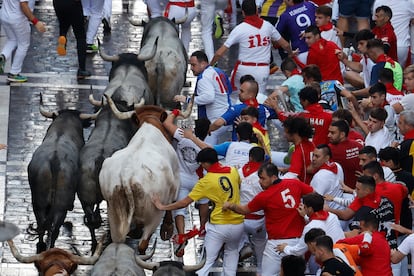Mozos corren al paso de los toros de la ganadería de José Escolar en el sexto encierro de los Sanfermines.