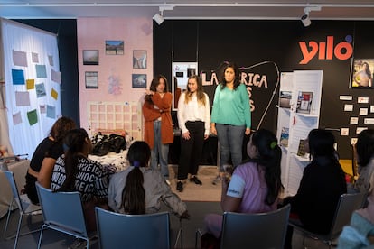 Niñas gitanas e integrantes del proyecto [J]itana, delante de un cartel de Yiló.