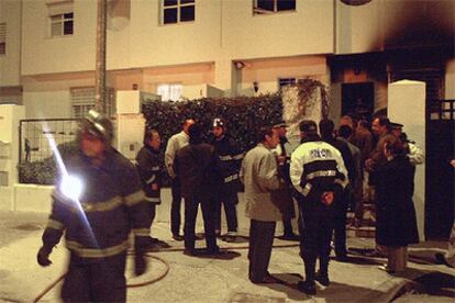 Miembros del Cuerpo de Bomberos y de la Policía Local ante el domicilio incendiado en la calle Sucre de Jerez (Cádiz).
