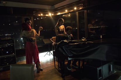 Um casal dança para acompanhar a melodia de um pianista no bar El Girasol em Maracaibo. A cidade era conhecida como "a mais fria" do país pelo uso massivo de ar condicionado. Hoje, todas as noites, a escassez de geradores levou muitas famílias a dormir à porta de suas casas, mal iluminadas por lâmpadas a gás.