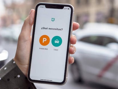 Una persona utiliza la aplicación de Joinup, que ahora incluye parkings además de taxis.