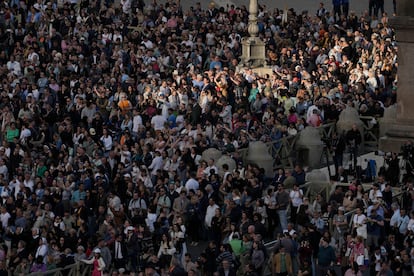 Fieles, curiosos y turistas esperan para ver la fumata desde la plaza de San Pedro en el Vaticano.