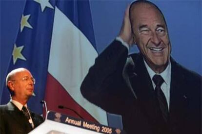 El presidente del Foro, Klaus Schwab, escucha la conferencia por vídeo del presidente francés Jacques Chirac.