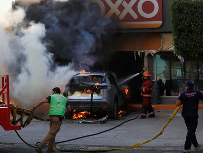 Bomberos apagan el fuego de un coche en Celaya, Guanajuato.