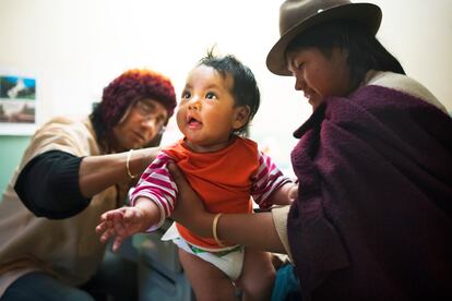 Una mujer sostiene a su bebé durante una consulta médica en Ecuador.