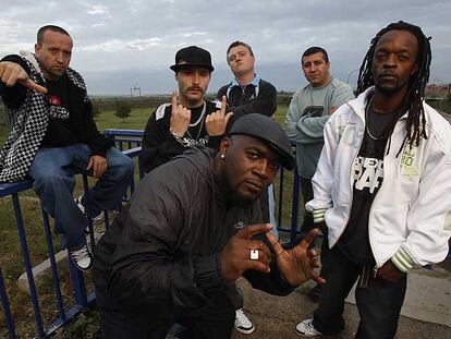 Figuras de los inicios y del momento actual del <i>rap</i> en Torrejón, con la base aérea al fondo. De izquierda a derecha, Randy, Cerroman 1/29, Blue Ice, Frank T, DJ Lara y Señor T Cee.