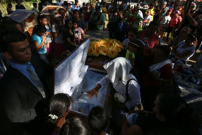 Familiares, vecinos y amigos observan los restos de José Pedro Rivera, uno de los migrantes salvadoreños fallecidos en el norte de México, durante su funeral en el cementerio municipal de Nueva Trinidad, en el departamento de Chalatenango, el 10 de abril de 2023.