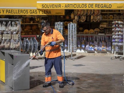 Un trabajador de la contrata municipal limpia unas papelera este martes en una calle del centro de Valencia. 