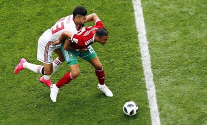 El delantero marroquí Aziz Bouhaddouz (Derecha) contra Ramin Rezaeian (Izquierda) durante la acción que ha acabado dándole la victoria a Irán con un gol en propia puerta.