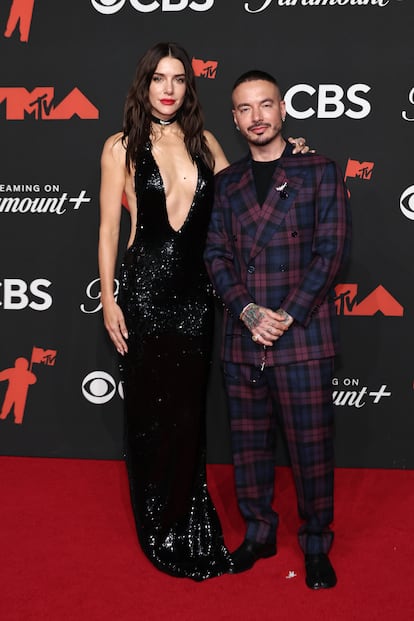 Valentina Ferrer, con vestido de lentejuelas negros, y  J Balvin, con traje de cuadros.