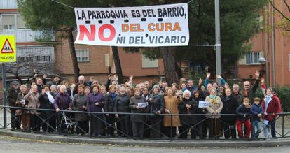 Feligreses católicos de Vallecas posan el último domingo de noviembre bajo una pancarta de protesta.