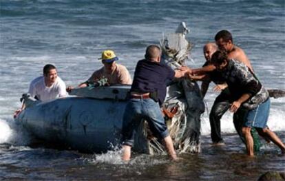 Miembros de la Guardia Civil y voluntarios sacan del agua los restos del fuselaje del F-18.