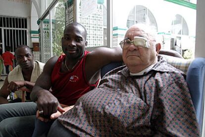 A la derecha, Ángel Rodríguez, párroco de la iglesia de San José Obrero (Málaga), junto a dos inmigrantes.