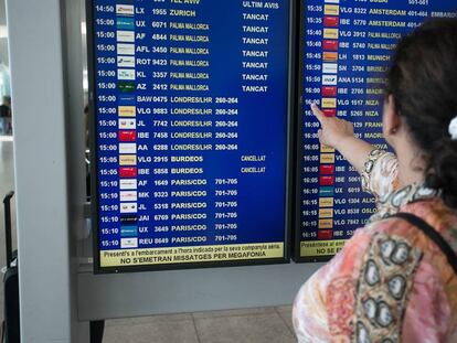 Una pasajera consulta la pantalla en el aeropuerto de El Prat.